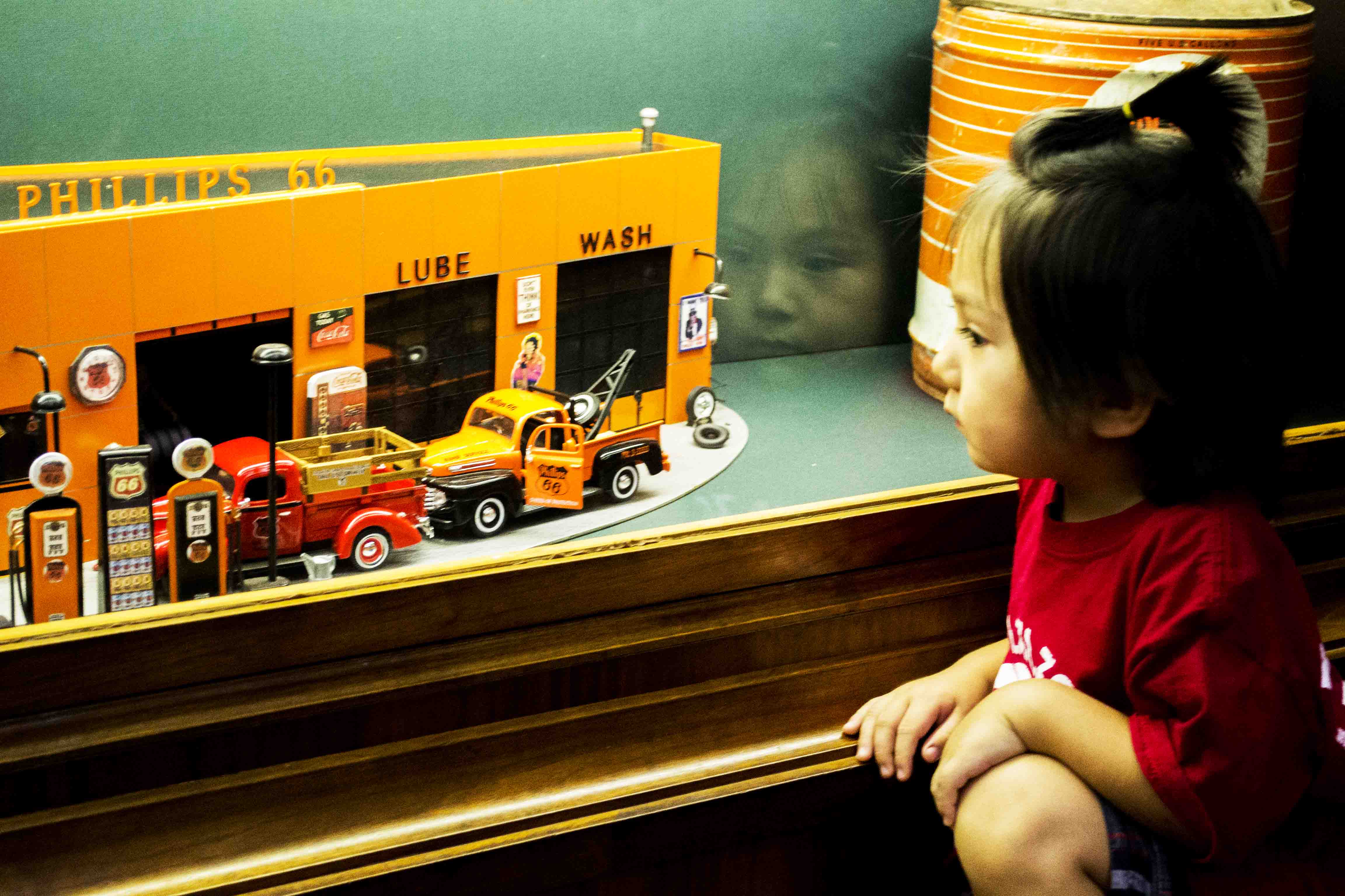 Liam Ashmore, 2, takes a closer look at a miniature Phillips 66 gas station at Woolaroc Museum.